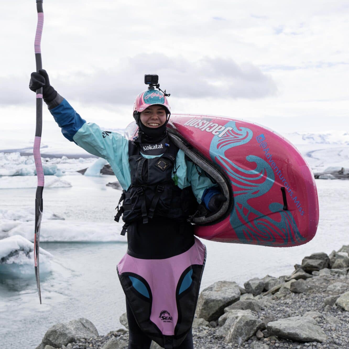 Abby Holcombe with a kayak on a coastline