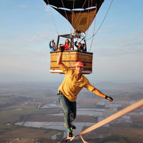 Davis Hermes slacklining in front of a hot air balloon.